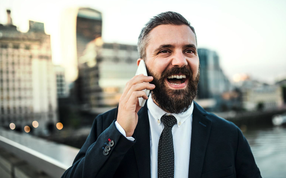 Homme d’affaire qui téléphone avec un iPhone pour illustrer la prise de rendez-vous avec ALis Business pour évaluer vos besoins en matériel informatique pour votre entreprise